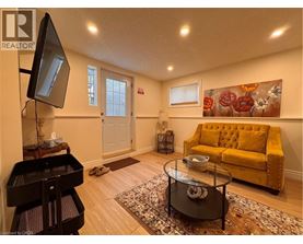 A living room with a yellow couch and a piano.