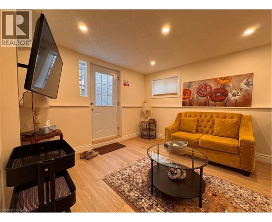 A living room with a yellow couch and a piano.