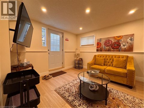 A living room with a yellow couch and a piano.