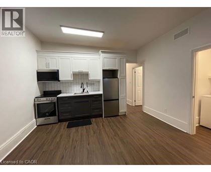A kitchen with white cabinets and black appliances.