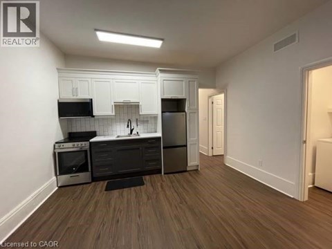 A kitchen with white cabinets and black appliances.