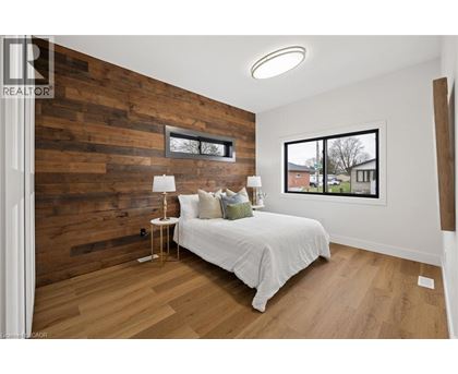 A bedroom with a white bed and a wooden wall.