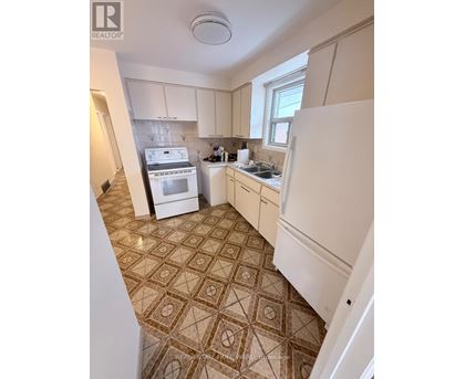A kitchen with a tile floor and white appliances.