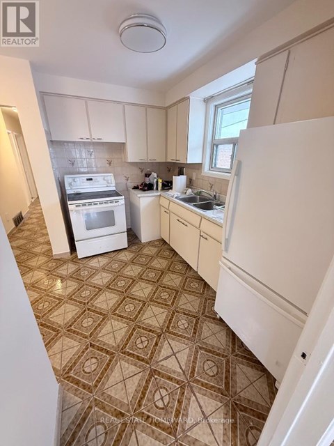 A kitchen with a tile floor and white appliances.