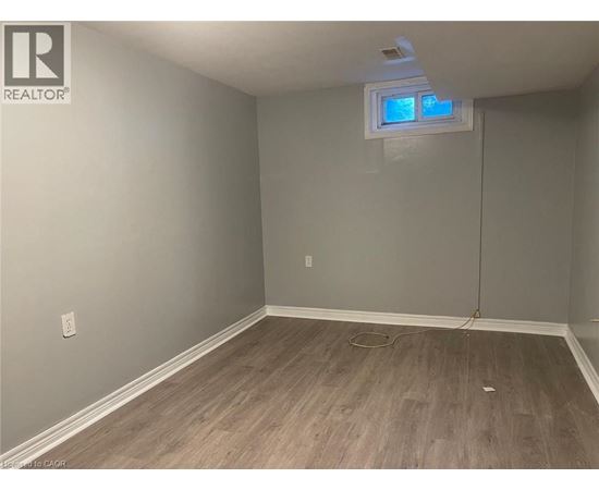 A room with a window and wooden flooring.
