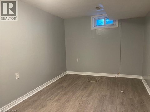 A room with a window and wooden flooring.