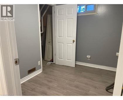 A room with a white door and a grey wall.