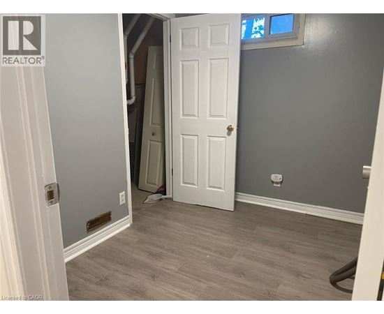 A room with a white door and a grey wall.