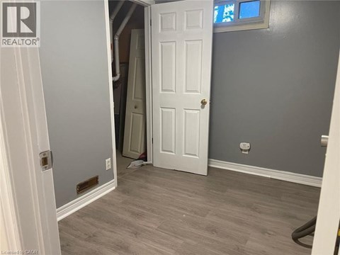 A room with a white door and a grey wall.