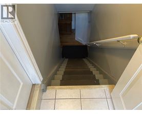 A staircase with a black carpet leading to a door.
