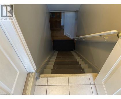 A staircase with a black carpet leading to a door.