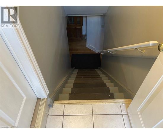 A staircase with a black carpet leading to a door.