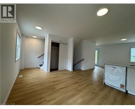 A large empty room with wooden floors and white walls.