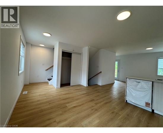A large empty room with wooden floors and white walls.