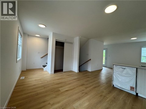 A large empty room with wooden floors and white walls.
