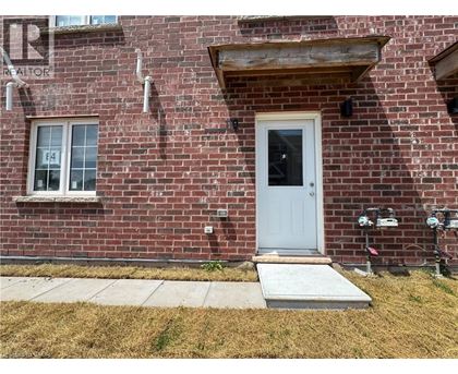 A red brick house with a white door and a small window.