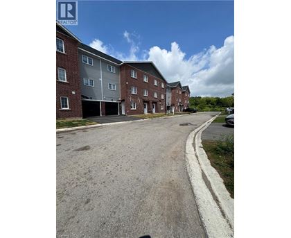 A large red brick apartment building with a parking lot in front.