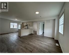 A spacious room with a wooden floor and white walls.