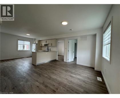 A spacious room with a wooden floor and white walls.