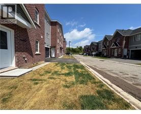 A row of houses with a grassy area in front.