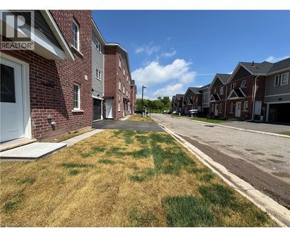 A row of houses with a grassy area in front.