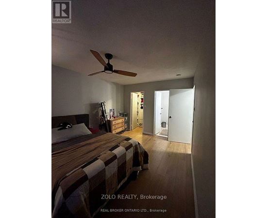 A bedroom with a bed, dresser, and ceiling fan.