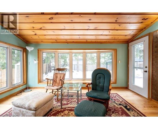 A living room with a green chair and a wooden ceiling.