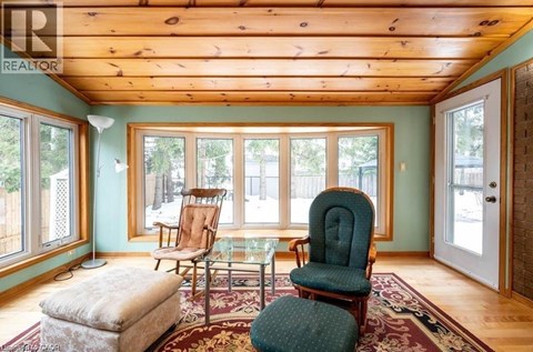 A living room with a green chair and a wooden ceiling.