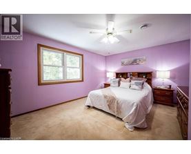A bedroom with a bed, dresser, and window.