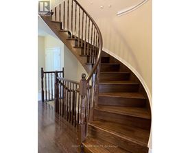 A wooden staircase with a metal railing.