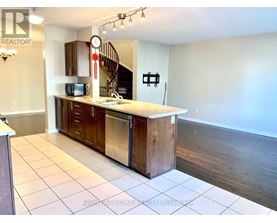 A kitchen with a refrigerator, oven, and microwave.