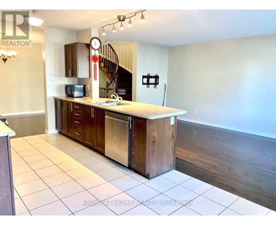 A kitchen with a refrigerator, oven, and microwave.