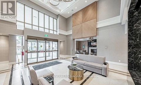 A spacious living room with a grey sofa and a coffee table.