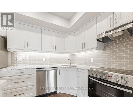 A kitchen with white cabinets and a stainless steel dishwasher.