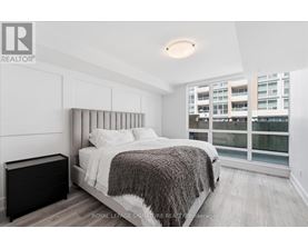 A bedroom with a large bed and a window overlooking a building.