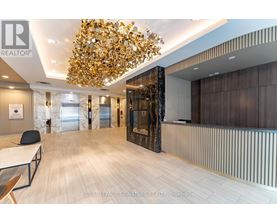A modern office space with a large chandelier and wooden flooring.