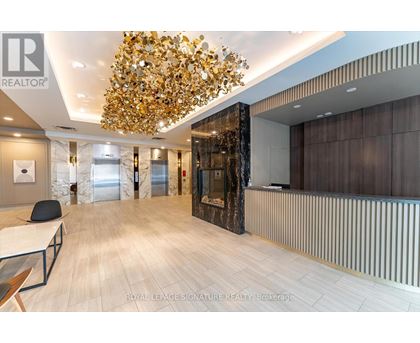 A modern office space with a large chandelier and wooden flooring.