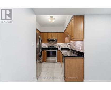 A kitchen with wooden cabinets and black countertops.