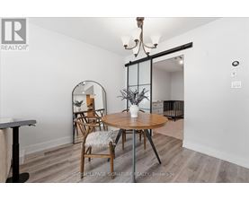 A dining room with a round table and chairs.