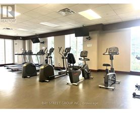 A gym with treadmills, elliptical machines and other exercise equipment.