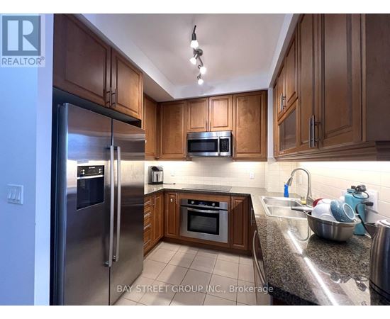 A kitchen with wooden cabinets and stainless steel appliances.