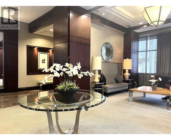A living room with a glass table and a sofa.