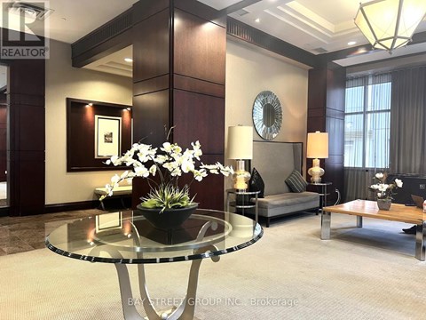 A living room with a glass table and a sofa.