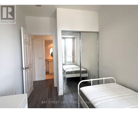 A bedroom with a bed and a mirror on the wall.
