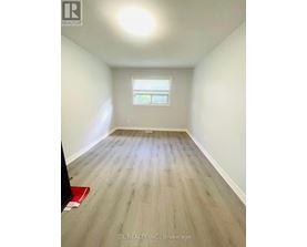 A room with wooden flooring and a window.