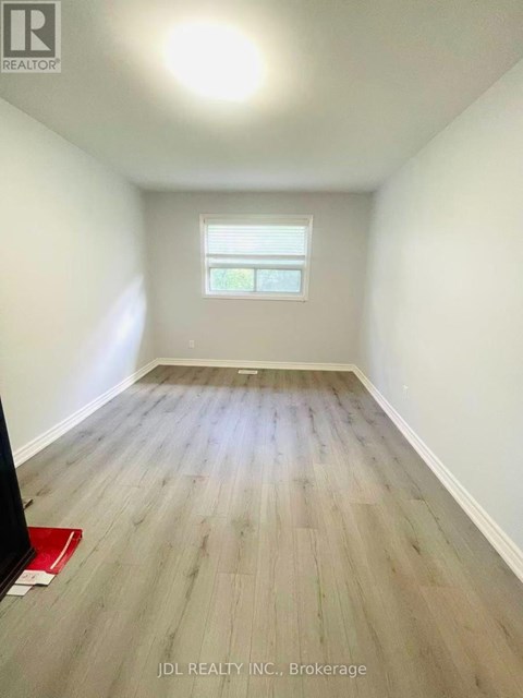 A room with wooden flooring and a window.