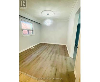 A room with wooden flooring and a window.