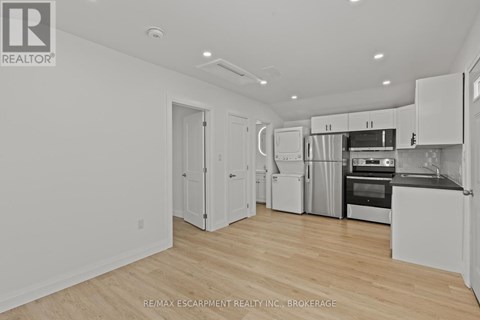 A white kitchen with wooden floors and white cabinets.