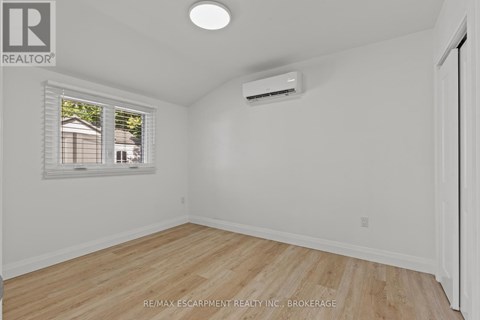 A room with a window and a wall-mounted air conditioner.