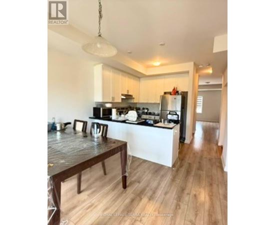 A kitchen with a wooden table and a white fridge.
